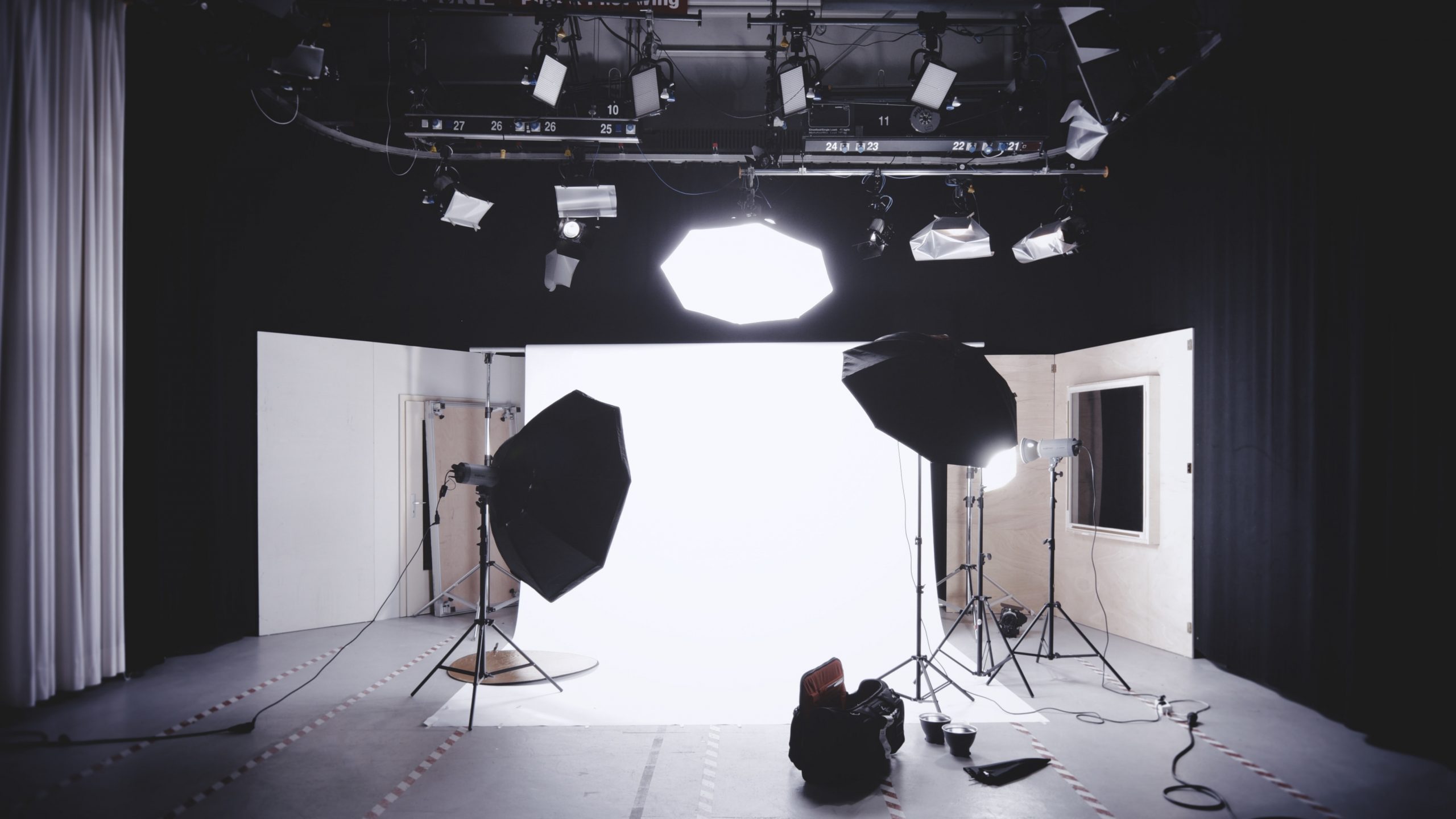 A photograph showing a photography studio with three lights read for a content shoot