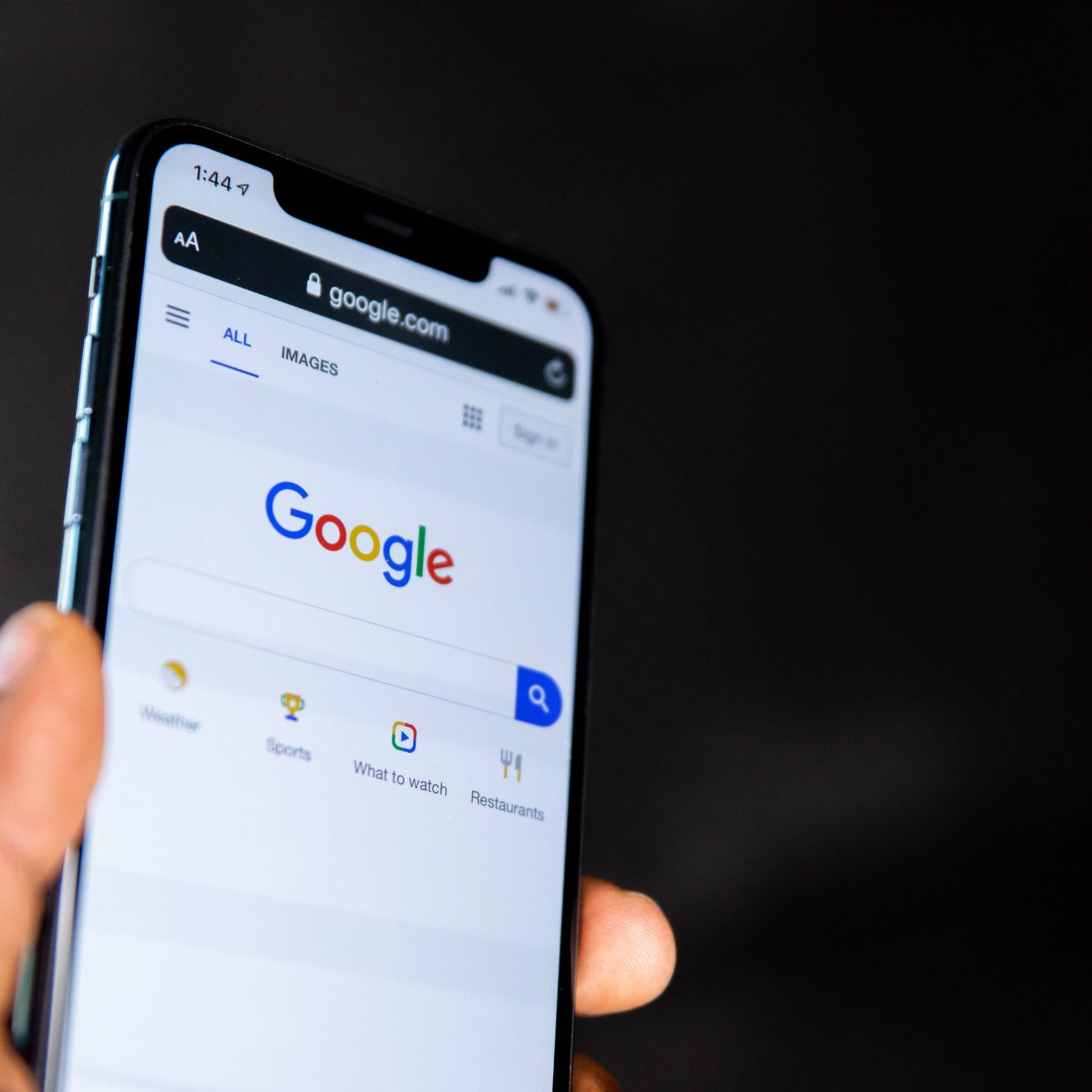 An image of a mobile phone showing a Google searchbar